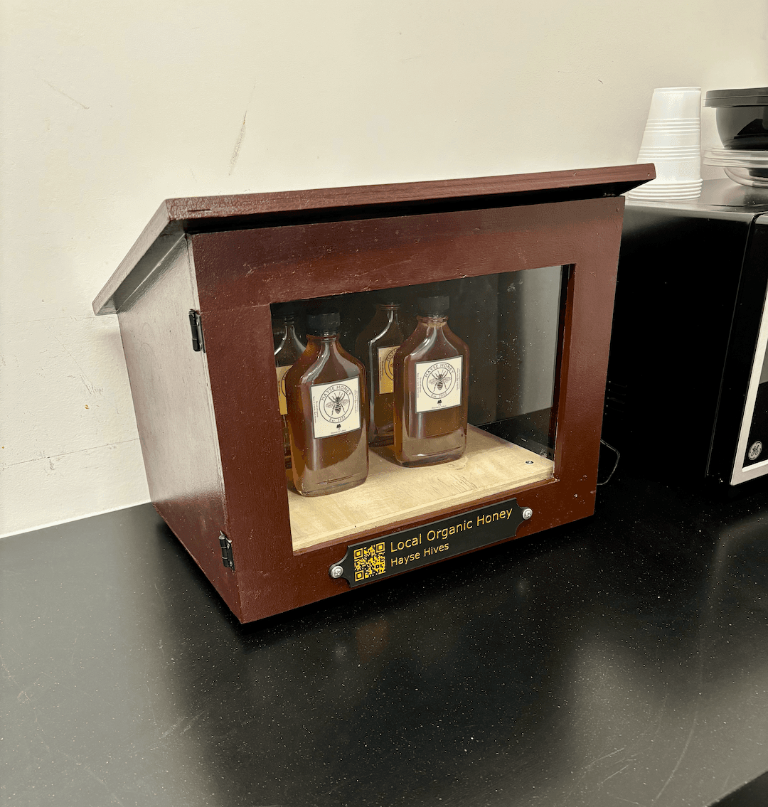 A wooden honey vending cabinet built by Hayse Hives, powered by Thingio